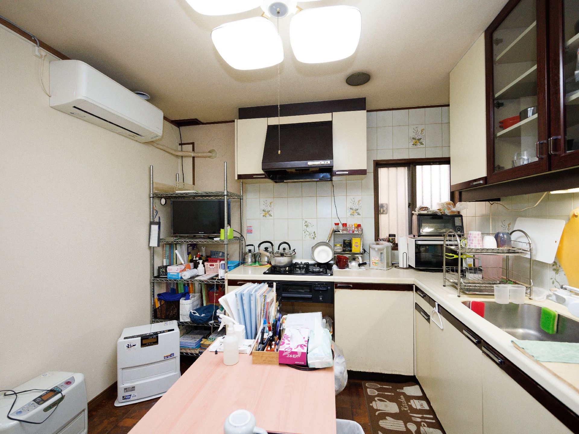 車いすの高齢女性とエプロンを付けた女性スタッフが手を取り合って微笑み合っている。