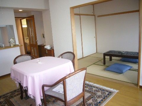和室を兼ね備えた居室。ダイニングスペースにはゆったり座れるひじ掛け付きの椅子とテーブルが設置されている。キッチンからダイニングが見渡せる。