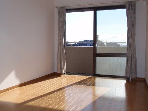 ベランダ付きの居室は、白い壁がスッキリとした印象である。大きな窓からは自然光がたっぷり差しこむのでとても明るい。