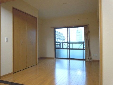 クリーム色の壁と、薄い色のフローリング、更に掃き出し窓から自然光が入って部屋全体が明るい。作り付けのクローゼットがある。