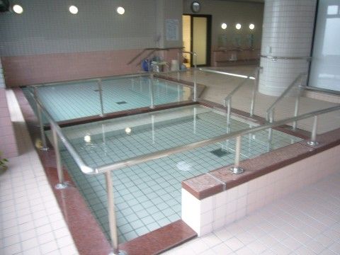 4，5人がゆったり入れる大きさの２つの浴槽は、手すりに掴まって入浴できる。床は全体がタイル張りでフラットである。