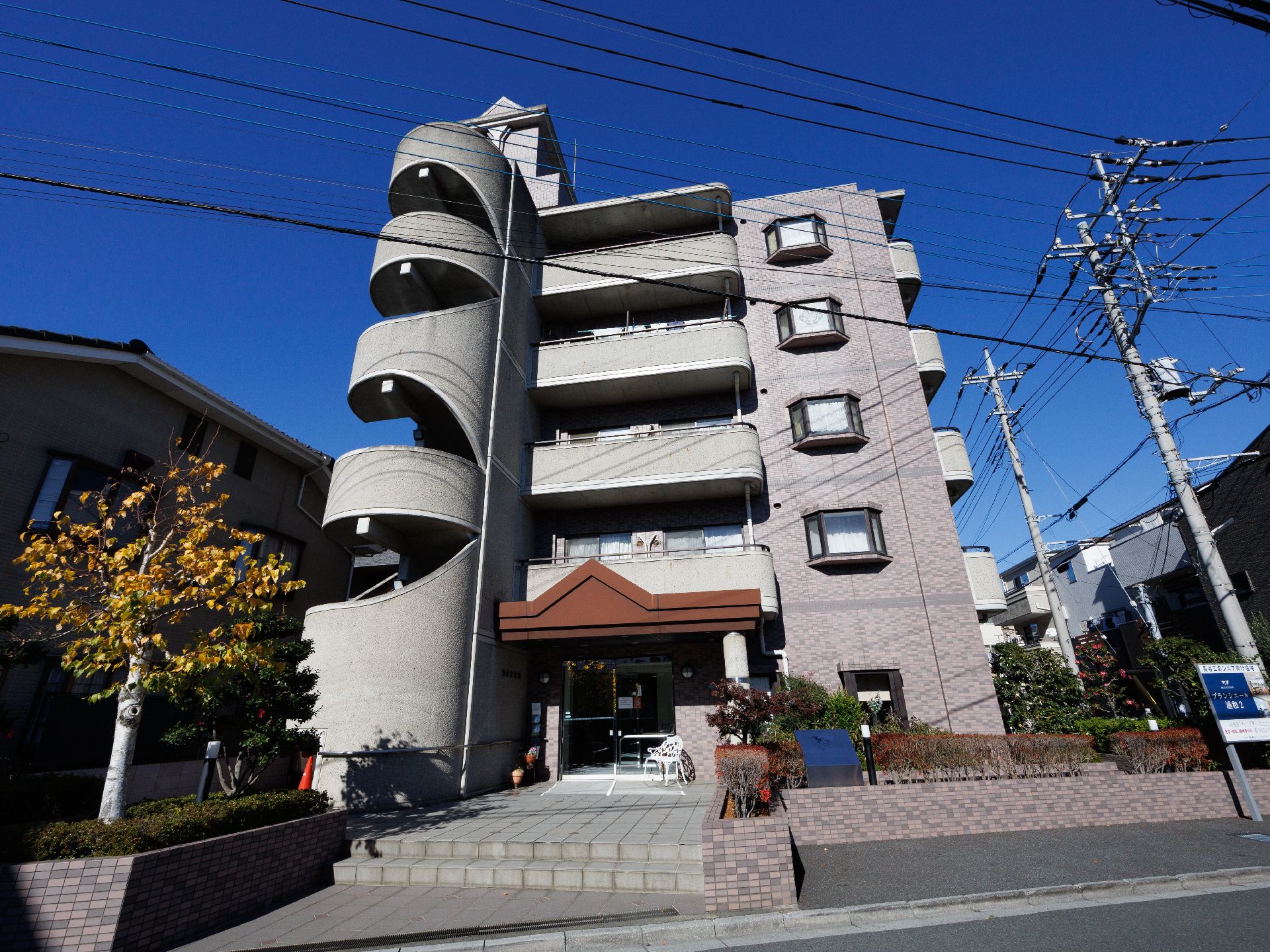 玄関先に白いベンチが配置されたマンションのような建物
