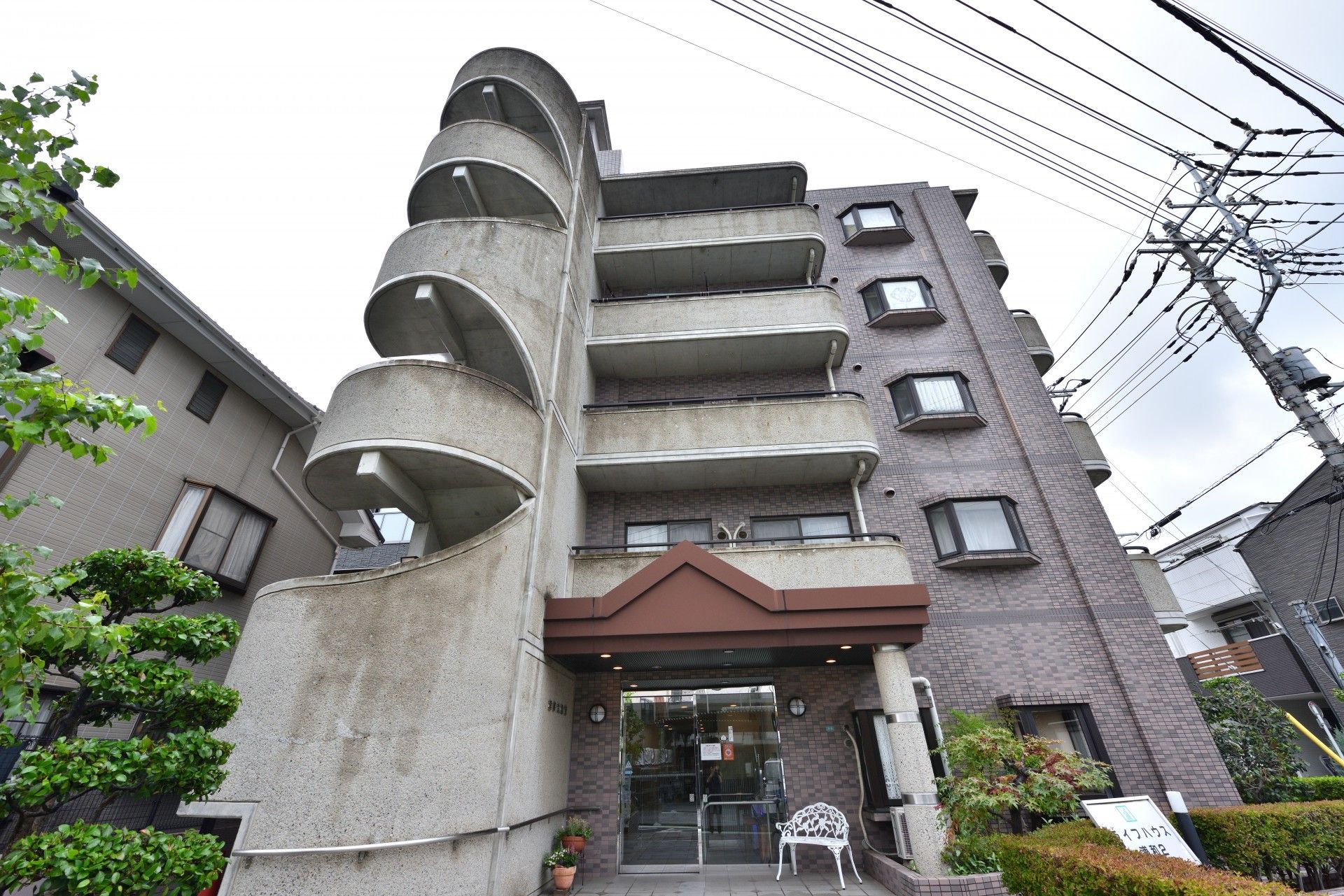 玄関先に白いベンチが配置されたマンションのような建物