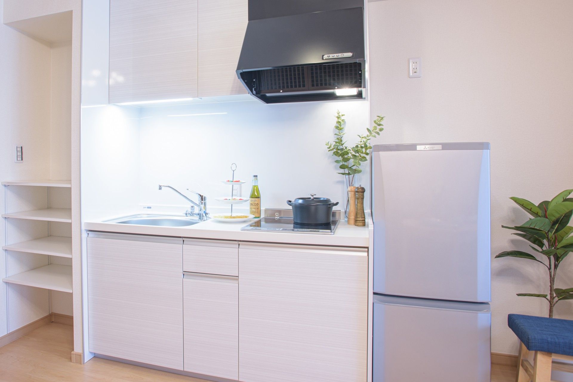 窓から入る自然光と、大きな照明から光が落ちる広々とした食堂。ダイニングセットのほか、テレビ前にソファがある。