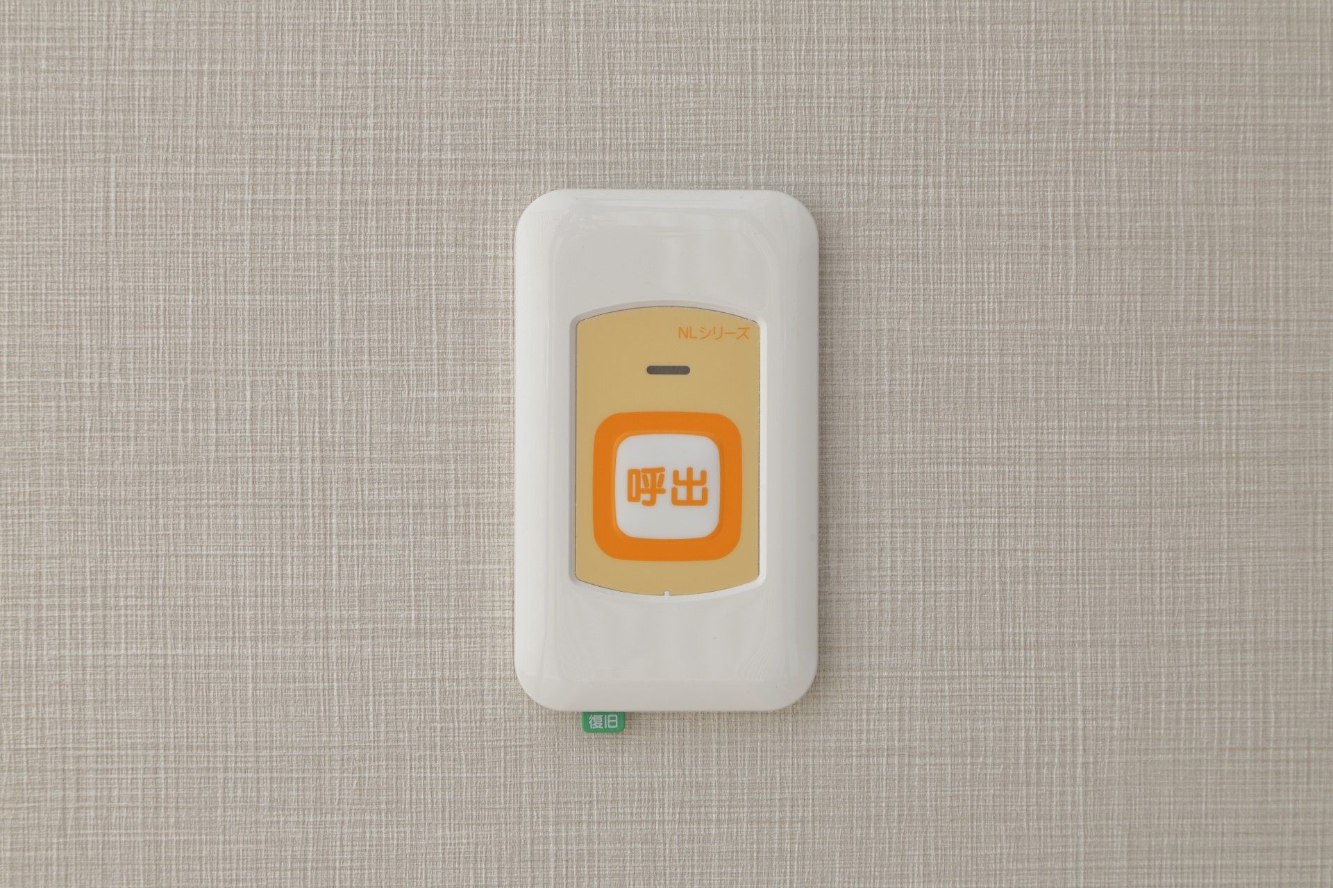 窓から外光が入る、落ち着いた部屋。エアコン付きで、木製の低床型のベッドと一人用のダイニングセットがある。