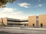 コの字型のブラウン系の建物の角フロアにベランダが付いている。日当たりのいい場所に建っている。