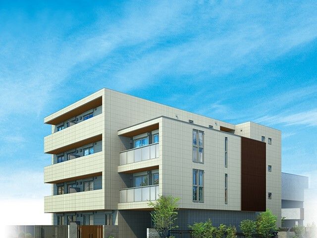 日当たりのいい場所に建っている白を基調とした建物。周りにはたくさんの草木が植えられている。