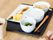 白いご飯に味噌汁、青菜の和え物、卵焼き、焼き鮭などがならんだトレーが置かれている。