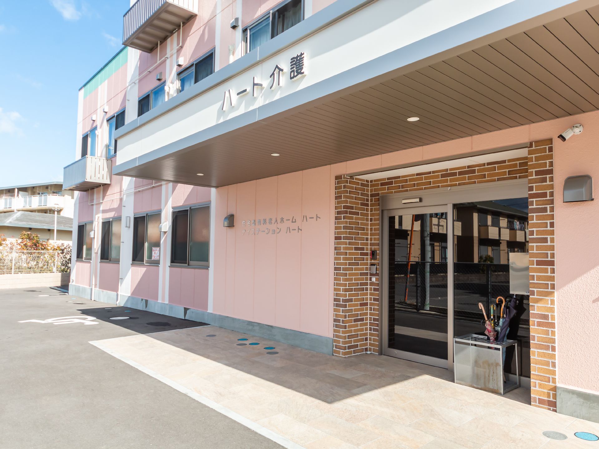 看板が設置され、段差が極力排除された介護施設の外観