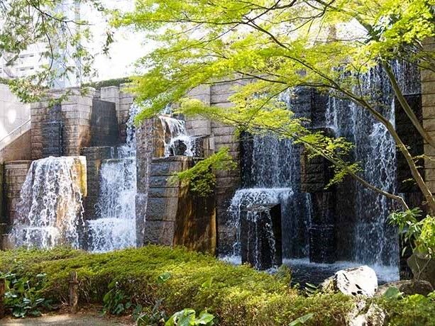 人工の滝が設置された庭園の一部。周りにはたくさんの草木が植えられている。