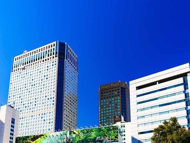 大きな白いビルが複数建ち並んでいる。奥にはPrince Hotelと書かれたブラウンの建物もある。
