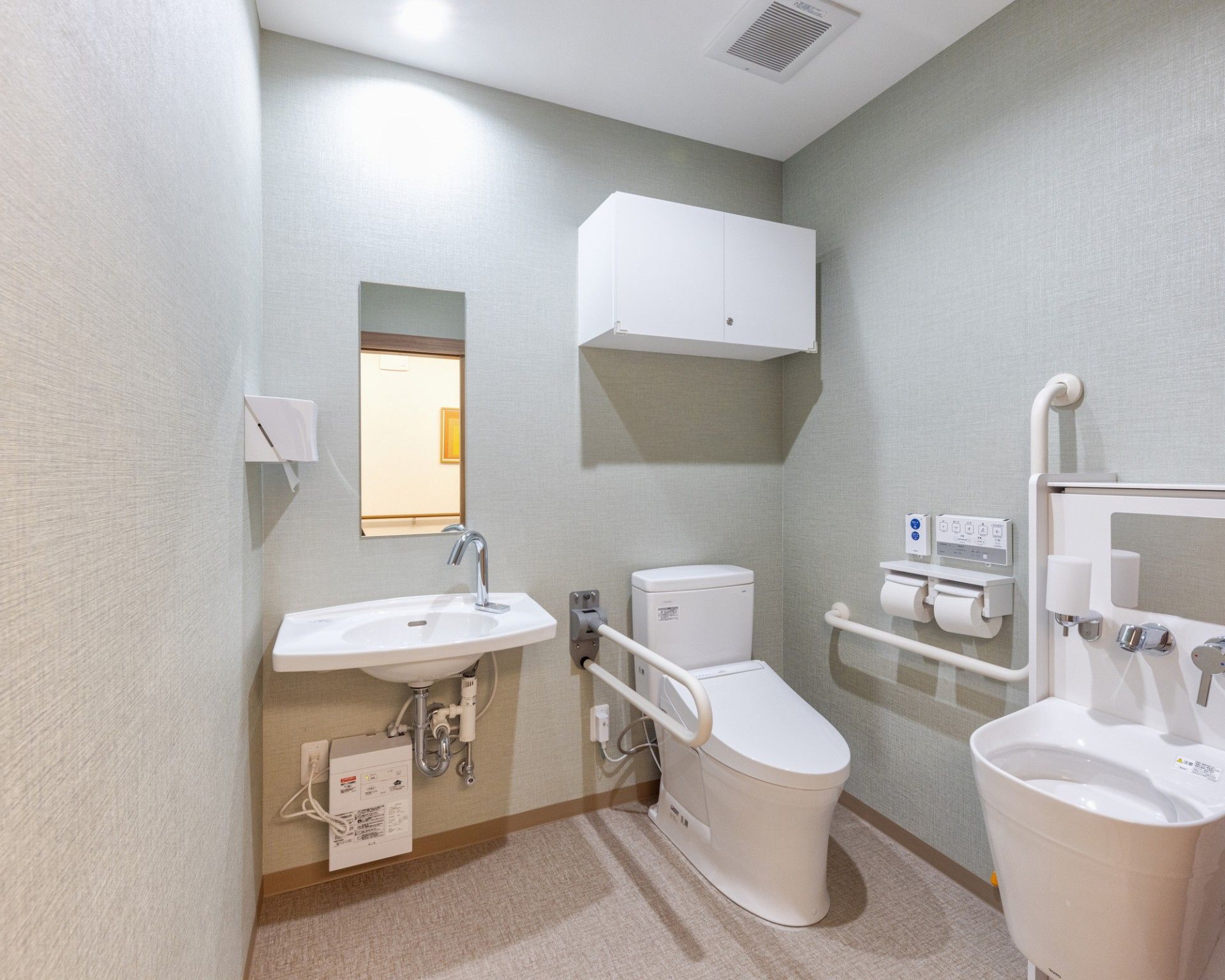 手すり付きの洋式トイレとオストメイト