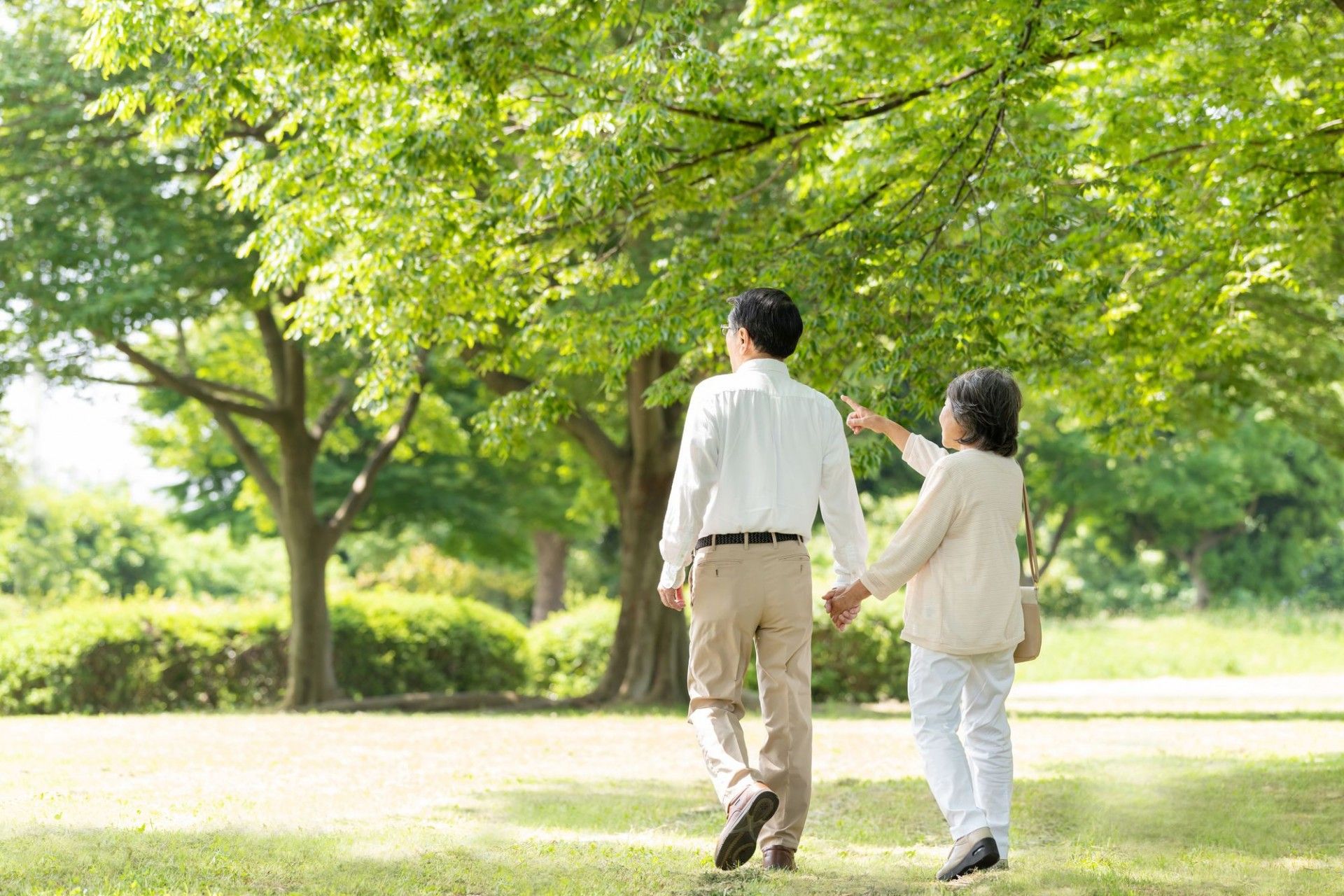眼鏡をかけた医師らしき男性がベッドに横になっている高齢者に聴診器を当てている様子。