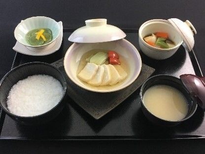 一人用の鍋の中にはミキサー状にしたものを肉や野菜の食材の形にしたものが入っていて、おかゆや具のない汁物、ムース状のおかずが並んでいる。