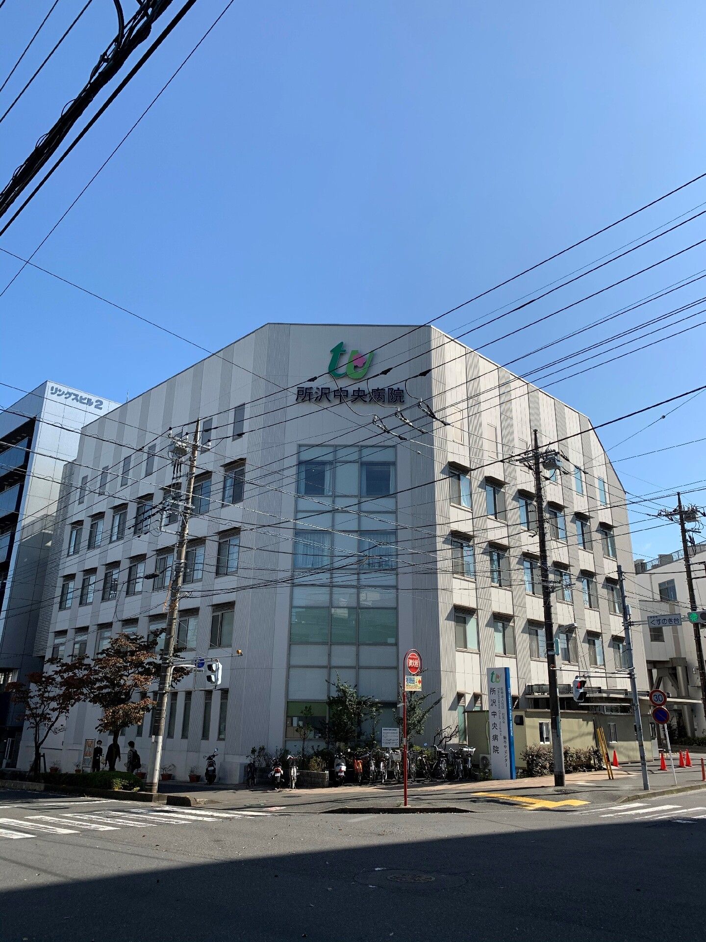 ダークブラウンの、がっちりとした建物である。手前には駐輪場が整備されており、点字ブロックが設置されている。