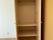 棚付きのクローゼットが付いているフローリングの部屋。扉が開いていて棚が付いているのが見える。