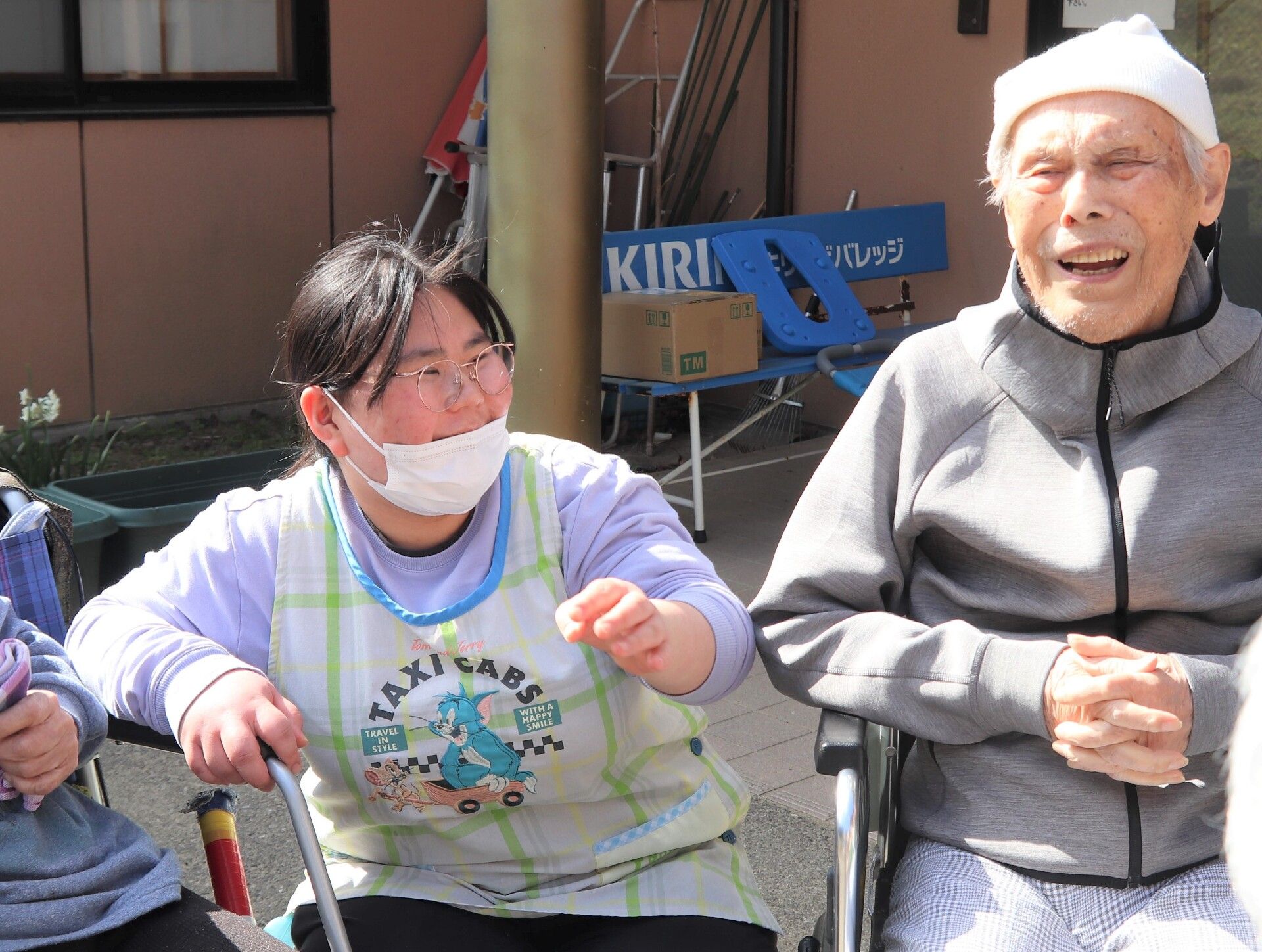 椅子に座る高齢者と寄り添う介護スタッフ