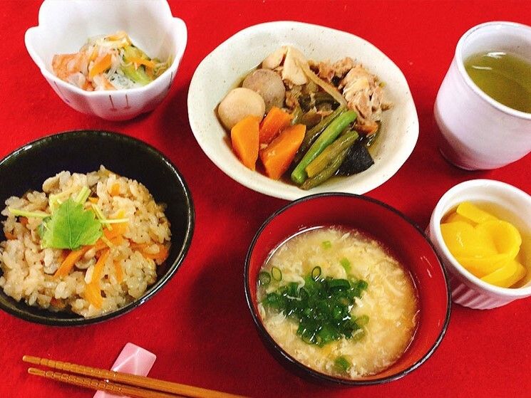 煮物や汁物、炊き込みご飯などが並んだテーブルには箸置きが置かれ、箸がセットされている。