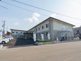 2階建てでツートーンカラーの建物と駐車場