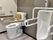男性用の小便器が右にあり、手すりが設置されている。左側にある洋式トイレにも手すりと背もたれがある。