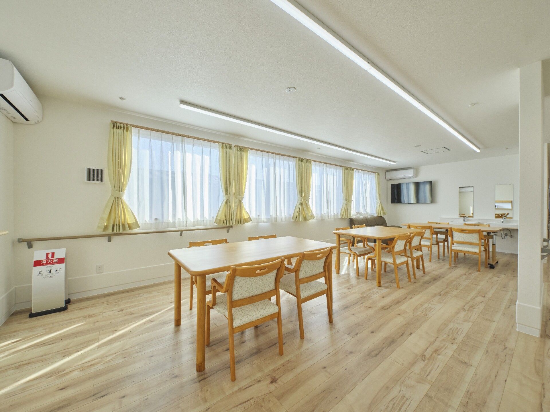 三角屋根が付いたブラウン系の２階建ての建物は日当たりのいい場所に建っている。玄関周りには手すりが設置されている。