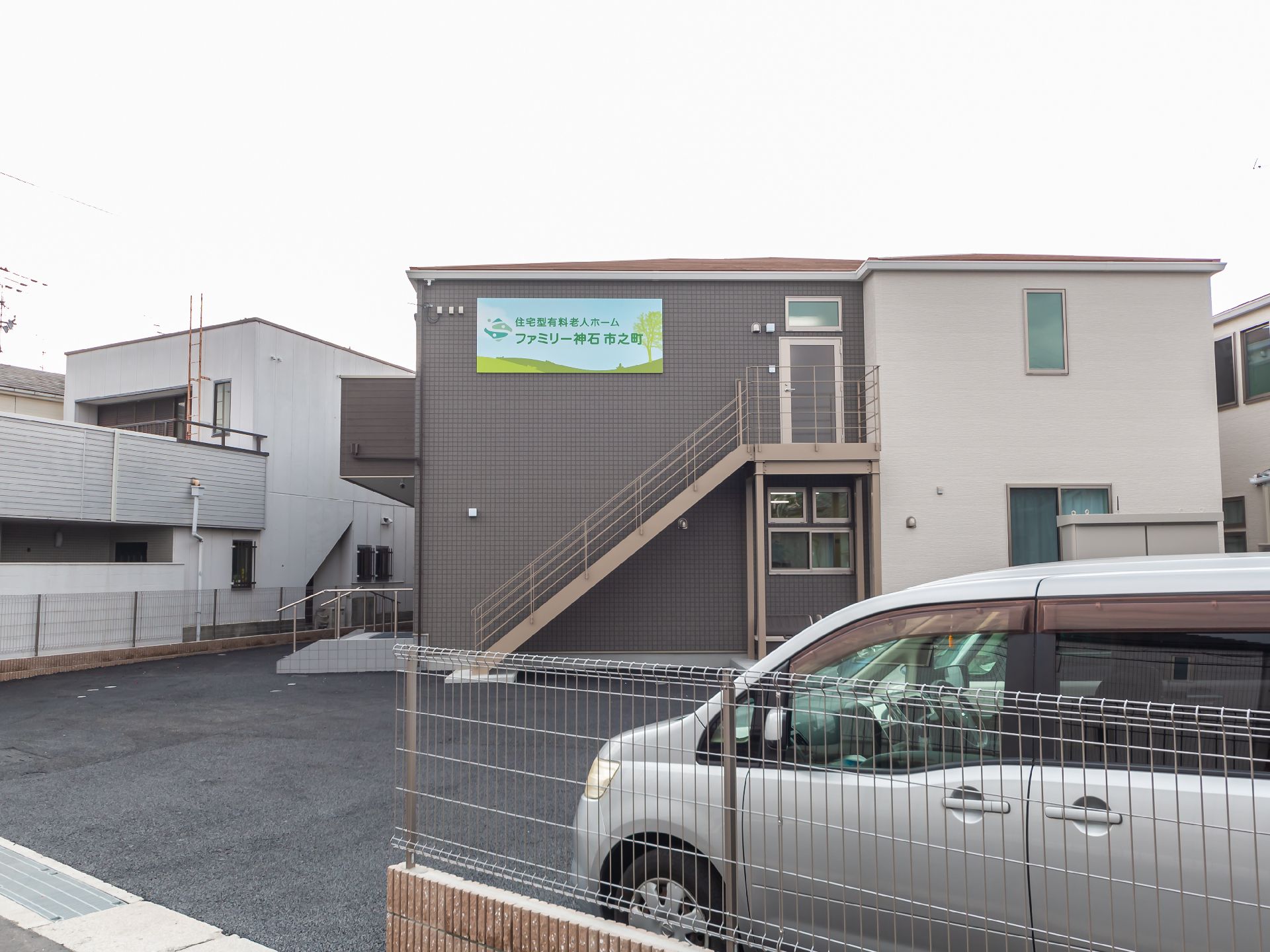 白とダークグレーの２階建ての建物