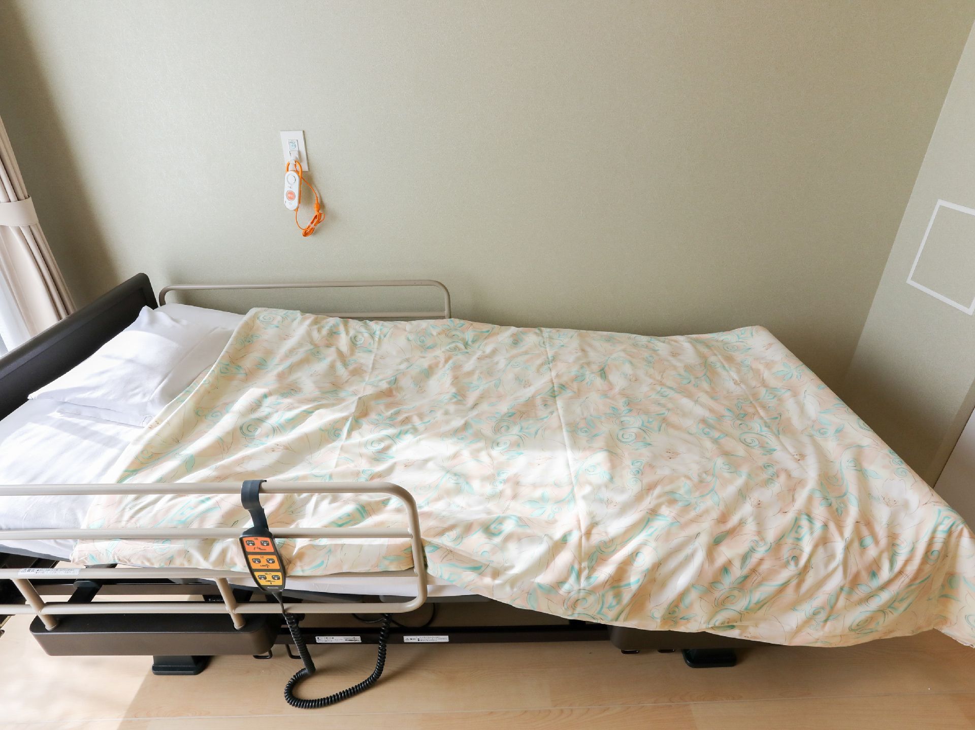 日差しが差し込み、介護ベッドが置かれている居室