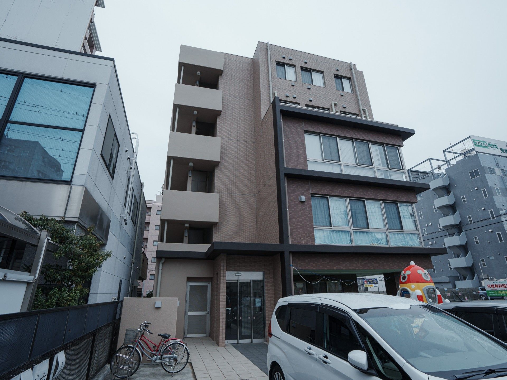 ベージュのソファを囲んで笑顔で話している高齢女性たちと白衣を着た女性スタッフ。