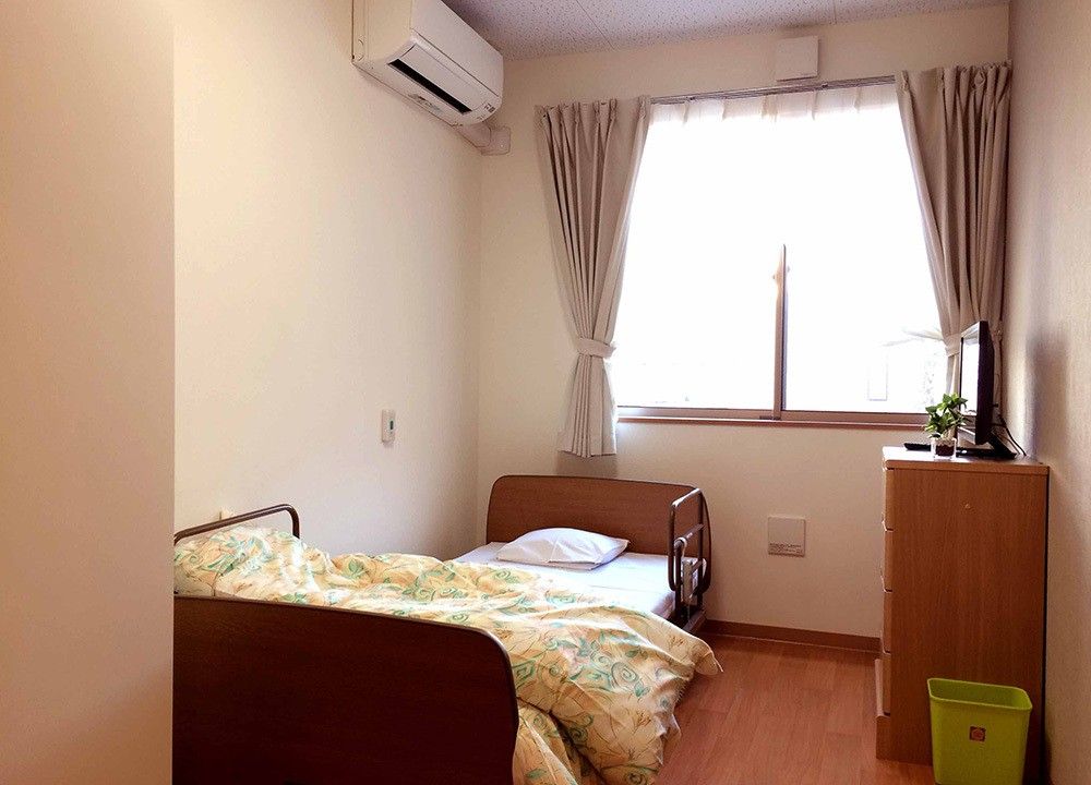 お部屋には介護ベッド、収納、エアコンが設置されている。