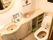 トイレと同じスペース内に手洗い場があり、大きな鏡が付いている。棚の上にはトイレットペーパーも置かれている。