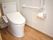 呼び出しボタンが設置されたトイレ内にはエル字型の手すりが設置され、フロアはフローリング。