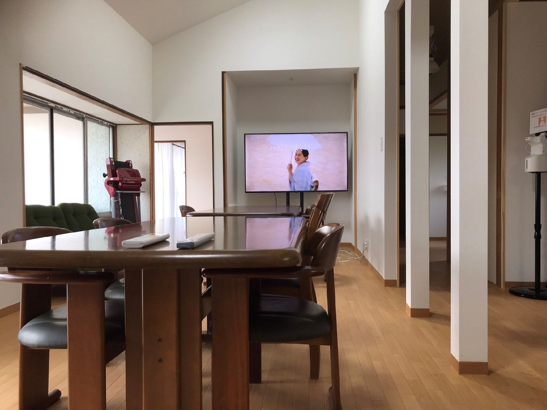薄いグレーのソファとレザー調のマッサージチェアが置かれているフローリングの部屋。