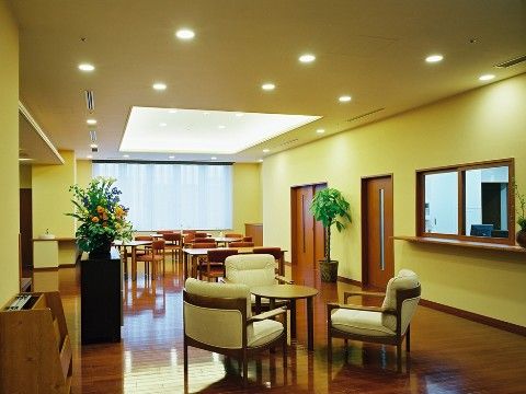 受付前にテーブルセットと観葉植物が配置された休憩スペース