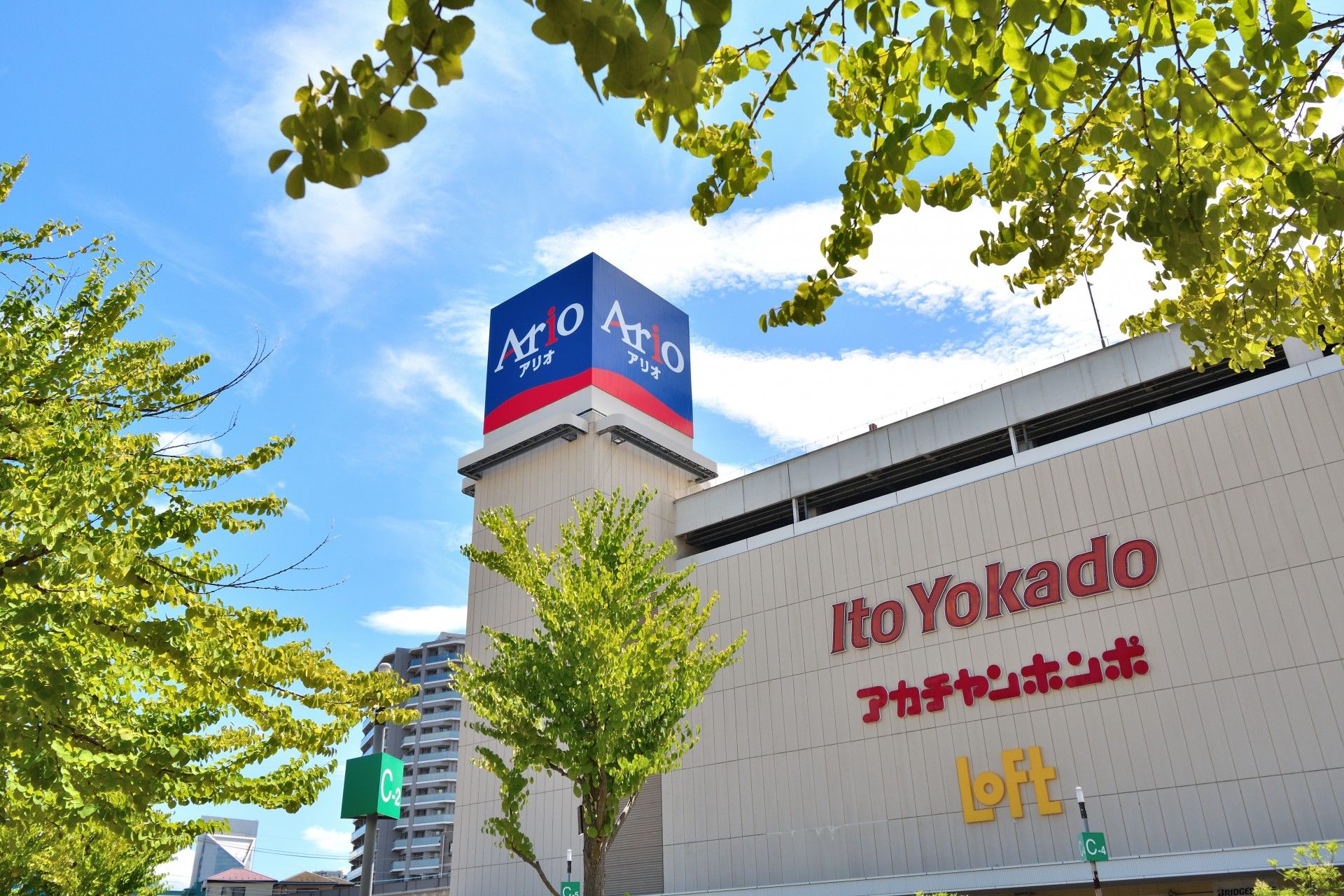 ホワイトとグレーで配色された壁に、アルファベット文字で店舗名が掲げられている。食料品や日用品など何でも揃う。