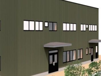 ブラウン系の外壁の2階建ての建物の周りには草木が植えられている。出入り口には屋根もある。