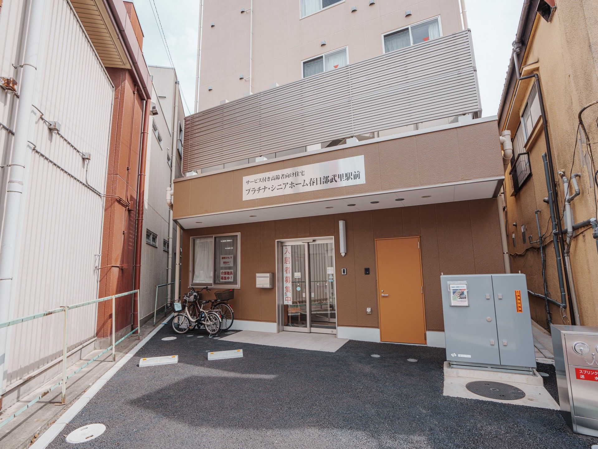 日当たりのいい場所に建っている６階建てのブラウン系の建物の各フロアにベランダがある。