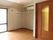 エアコンが付いたフローリングの部屋には家具はなく、カーテンのない大きな窓がある。