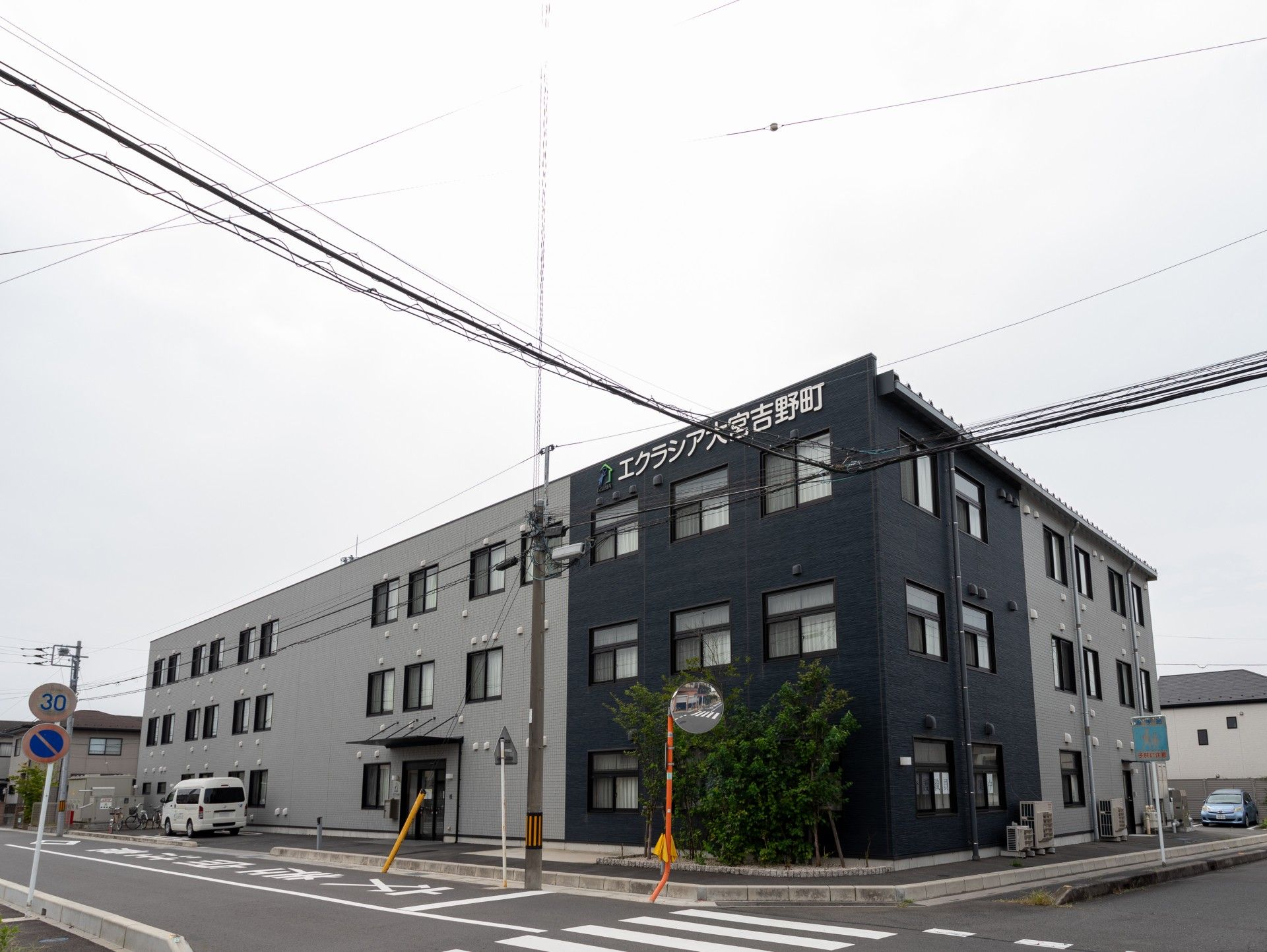 濃茶と薄茶のツートンカラーの外壁の3階建て建築物