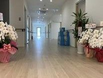 お祝いの花が飾られているまっすぐな廊下は両サイドに手すりがつい、居室のドアも並んでいる。