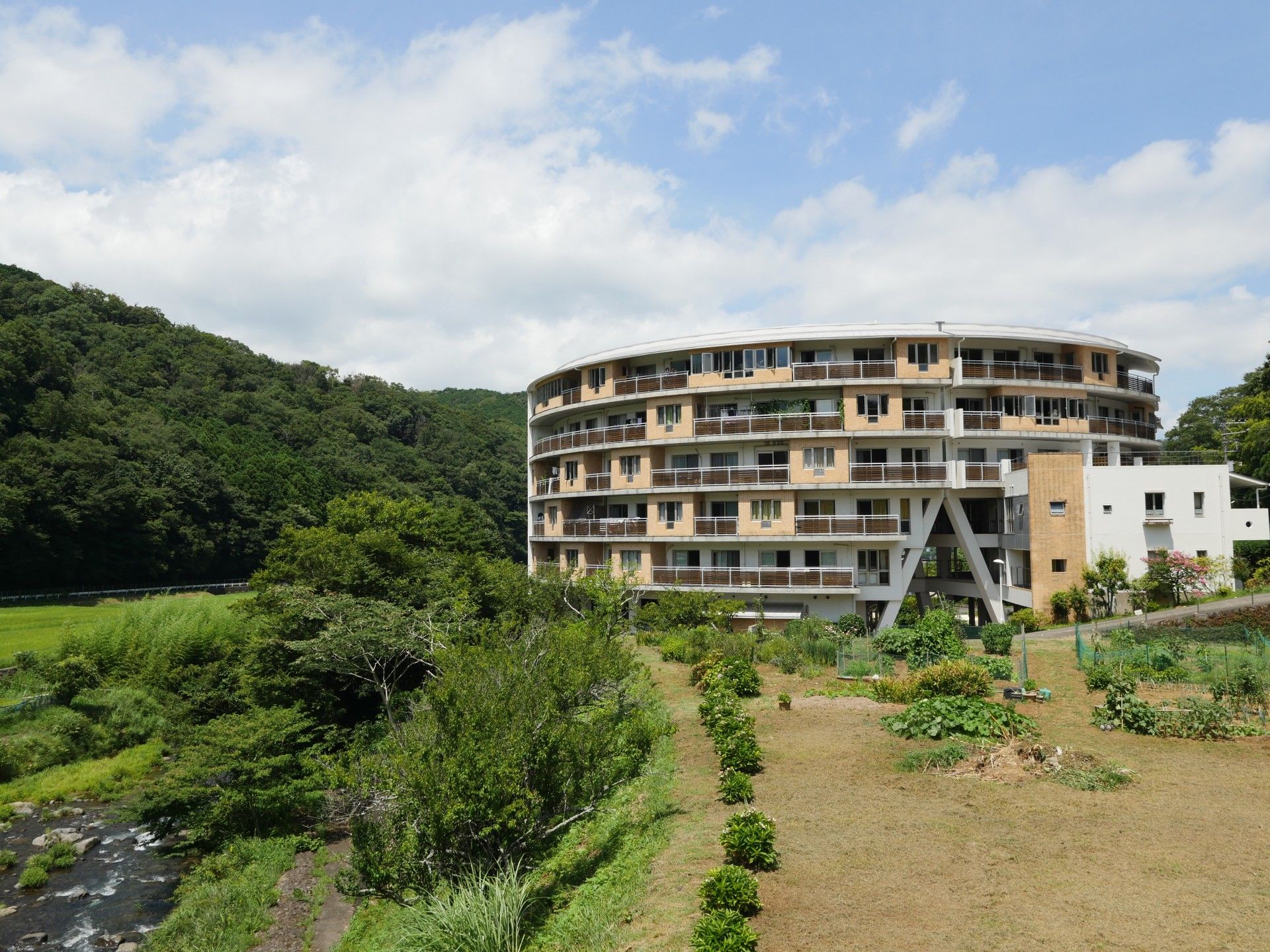 山のふもとに建設された施設の建物である。車の往来は関係車両以外になく、入居者様は静かな環境で過ごすことができる。