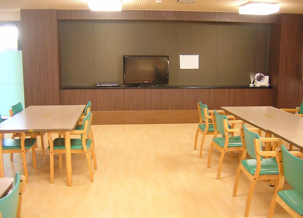 広いテーブルとイス、テレビが設置されている。