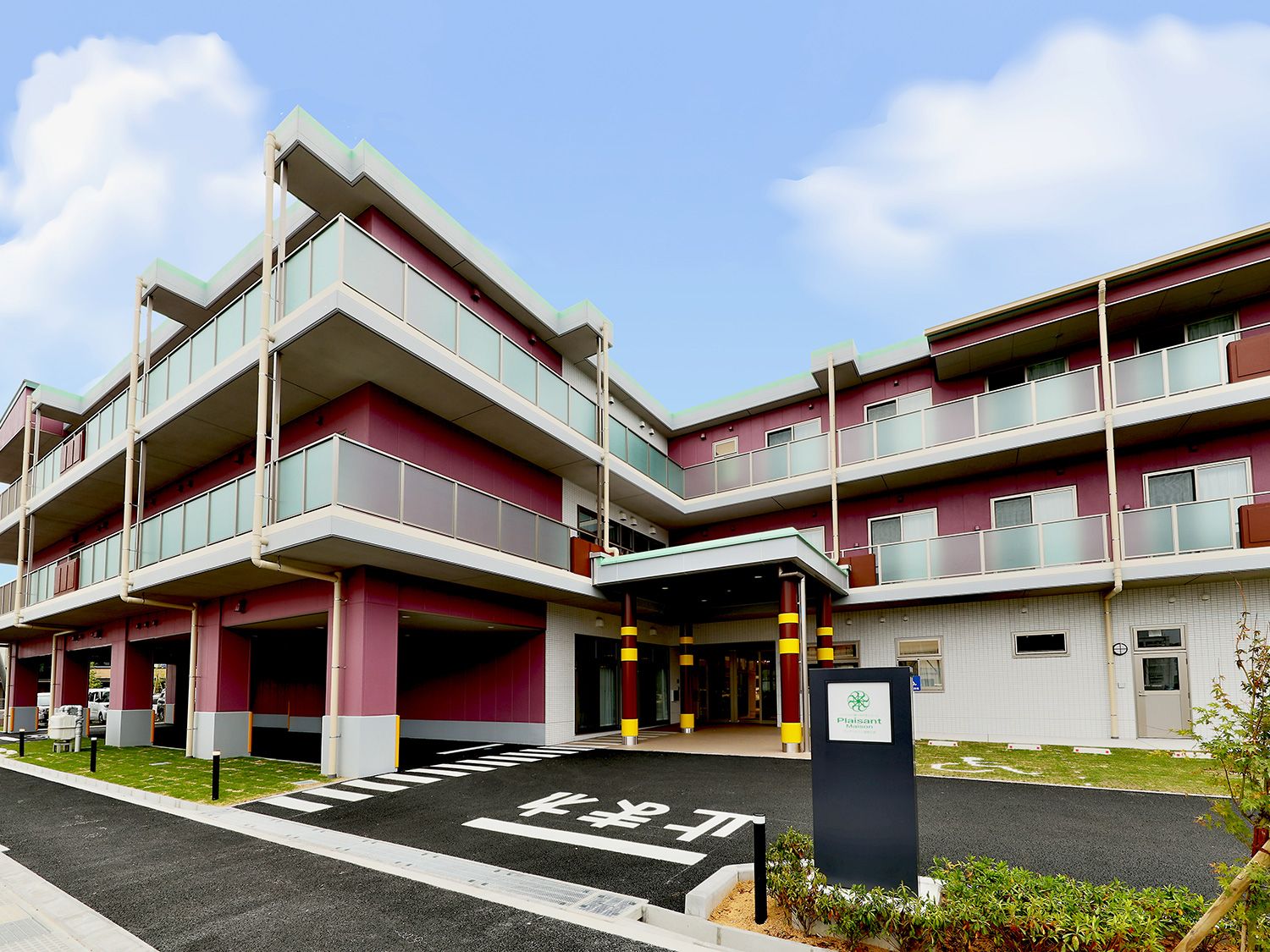 桜並木がある広い駐車場と3階建ての建物