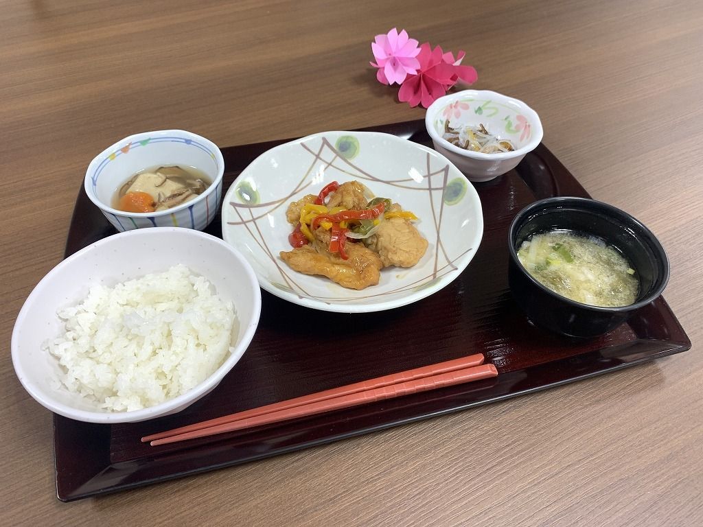 魚のあんかけに白いご飯、かきたま汁、野菜の小鉢などが並んだトレー。