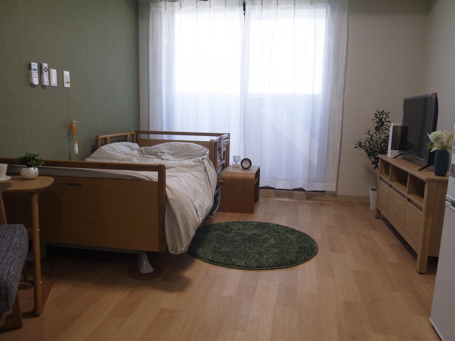 丸いラグがベットの足元に敷いてあり、テレビはテレビ台に乗せてある