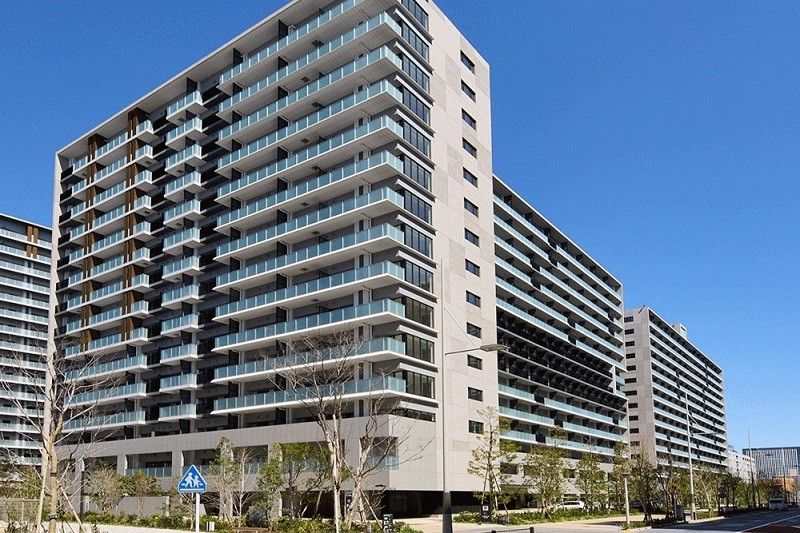 たくさんの高層ビルが建ち並ぶ交差点周辺には緑も多く植えられ、人々が歩いている。
