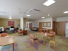 ダイニングテーブルセットが複数置かれている食堂とテレビが置かれたリビングが同じスペースにある。