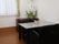 花が飾られた部屋には応接セットがあり、壁にはエアコンが付いている。