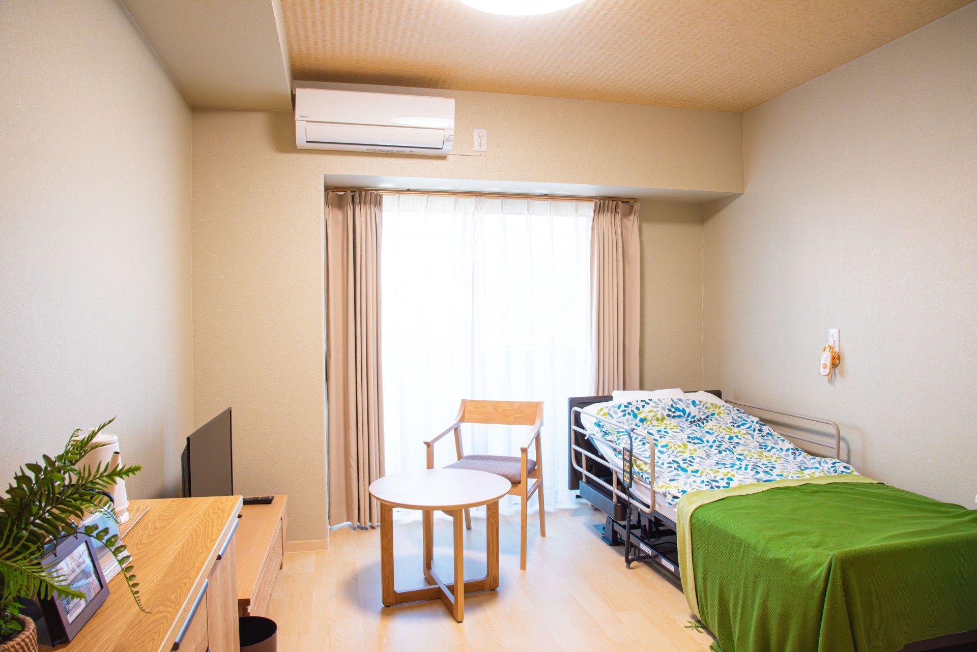 フローリングの部屋にはいすやテーブル、タンスやエアコン、クローゼットが付いている。