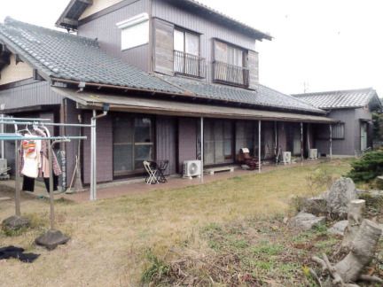 広い庭付きの和風の２階建ての建物。庭には洗濯物干し場もあり、軒下にはベンチなども置かれている。