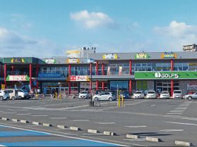 広い駐車場が付いたショッピングセンター。様々なタイプの店舗が集まっている。